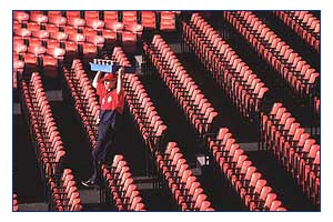 Hawker passes by empty red seats