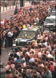 The flower-covered hearse carrying the coffin of Princess Diana drives past some of the thousands of mourners lined up on Finchley Road in North London.